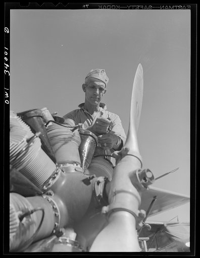 Untitled photo, possibly related to: Corpus Christi, Texas. Sergeant George Caveres, a member of the Civil Air Patrol, working on the motor of a plane. Sergeant Caveres formerly operated a garage in Corpus Christi