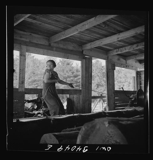 Turkey Pond, near Concord, New Hampshire. Women workers employed by a U.S. Department of Agriculture timber salvage sawmill. Mrs. Dorothy De Greenia, slip woman, pulling out the cable to throw it back down the slip for the next load of logs from the pond