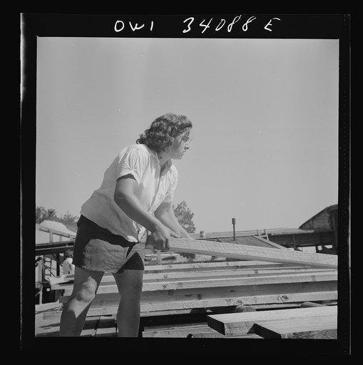 Turkey Pond, near Concord, New Hampshire. Women workers employed by a U.S. Department of Agriculture timber salvage sawmill. Ruth De Roche, pit woman, placing a trimmed board on the proper pile in the pit