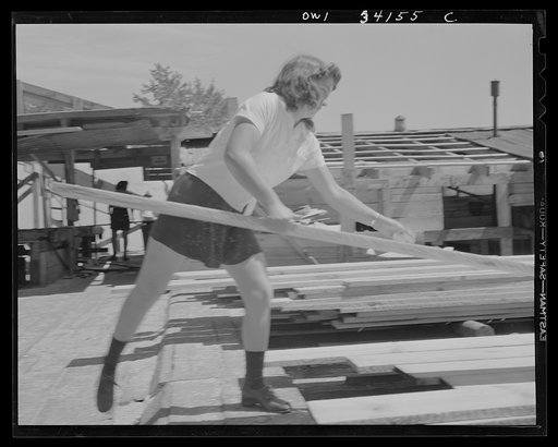 Turkey Pond, near Concord, New Hampshire. Women workers employed by a U.S. Department of Agriculture timber salvage sawmill. Norma Webber, pit woman, throwing a board on its pile. Boards are heavy but the mill is laid out with a conveyor system so that lifting and carrying is kept at a minimum