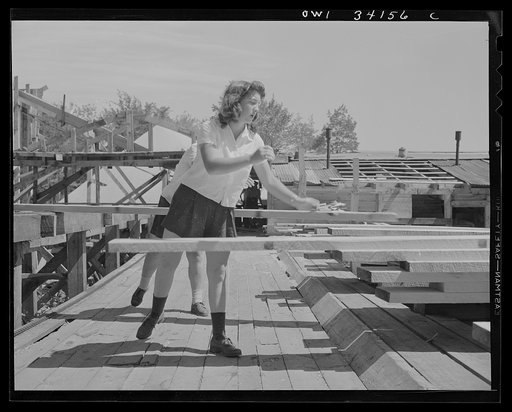 Untitled photo, possibly related to: Turkey Pond, near Concord, New Hampshire. Women workers employed by a U.S. Department of Agriculture timber salvage sawmill. Norma Webber, pit woman, throwing a board on its pile. Boards are heavy but the mill is laid out with a conveyor system so that lifting an
