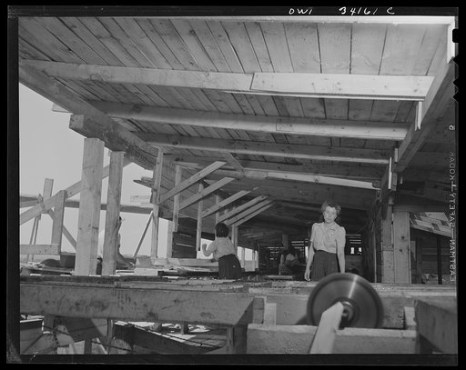 Untitled photo, possibly related to: Turkey Pond, near Concord, New Hampshire. Women workers employed by a U.S. Department of Agriculture timber salvage sawmill. As a board comes away from the edges, Mrs. Lucy DeGreen, right, taking away from the edges and putting them on a conveyor to be sawed into