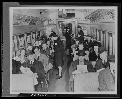 Long Island Railroad passenger coach manned by the first women trainmen on this line, who started work the day after an intensive training period. Mrs. Florence L. Lawyer (foreground) collecting tickets, while Miss Marcella Craft (background) gives information from her timetable to a passenegr