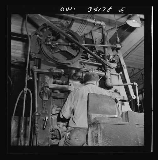 Untitled photo, possibly related to: New Britain, Connecticut A core blowing machine. Sand is blown into the core box as it travels away from the machine on a conveyor