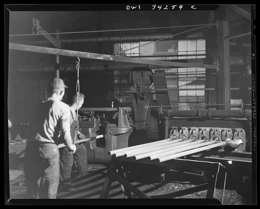New Britain, Connecticut. Oil fuel furnace showing several bars being heated. A lever crane is being used to transfer a bar to the forging machine at the Fafnir Bearing Company