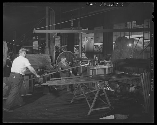 New Britain, Connecticut. Oil fuel furnace showing several bars being heated. A lever crane is being used to transfer a bar to the forging machine at the Fafnir Bearing Company