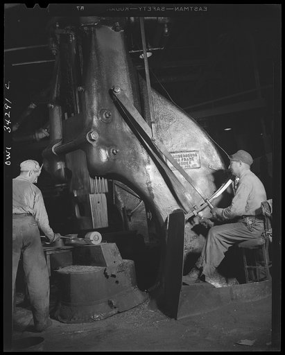 New Britain, Connecticut. Peter Juliana, steam-hammer operator and Bidwell Hughes, steam-hammersmith, working with a Chamers-ring steam hammer at the Fafnir Bearing Company
