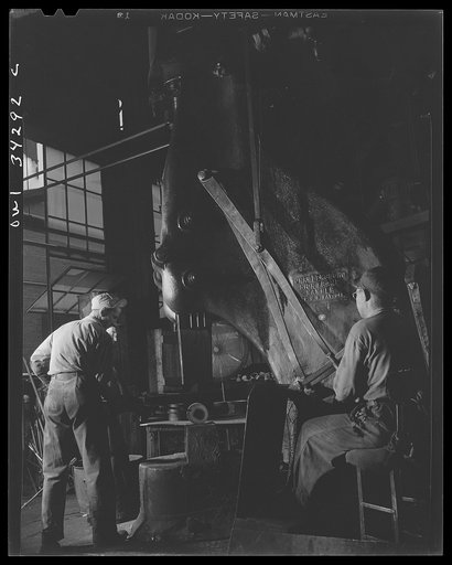 Untitled photo, possibly related to: New Britain, Connecticut. Peter Juliana, steam-hammer operator and Bidwell Hughes, steam-hammersmith, working with a Chamers-ring steam hammer at the Fafnir Bearing Company