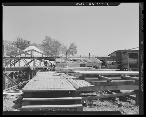 Untitled photo, possibly related to: Turkey Pond, near Concord, New Hampshire. Women workers employed by a United State Department of Agriculture timber salvage sawmill. "The pit," where cut and trimmed lumber is sorted in piles according to size. In the background is part of the mill, and the sawdu