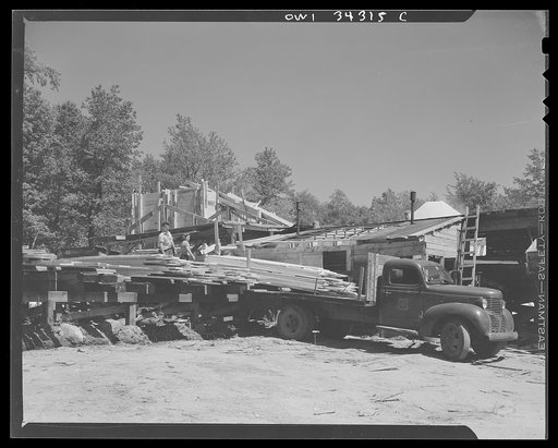 Turkey Pond, near Concord, New Hampshire. Women workers employed by a U.S. Department of Agriculture timber salvage sawmill. Finished boards, sorted at the "pit," are loaded into the truck by Linwood Perkins, and taken to the "sticking field" to dry. Mr. Perkins' wife, Daisy, also works at the sawmi