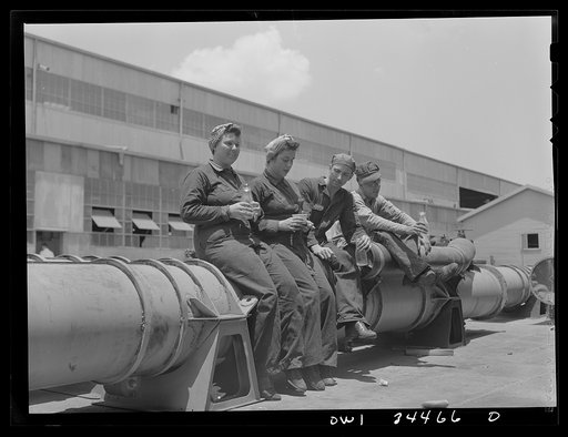 Higgins shipyards, New Orleans, Louisiana. Shipyard workers eating on a torpedo during their lunch hour