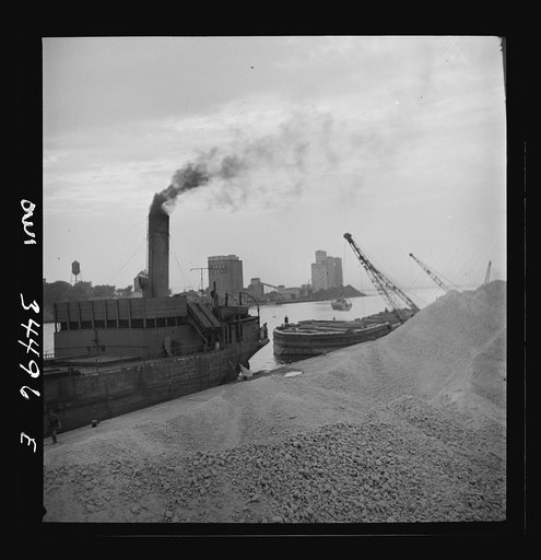 Oswego, New York. Unloading bauxite from a barge onto a Canadian boat which has come up through the inland waterways from Dutch Guiana