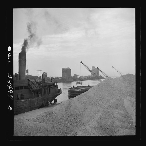 Oswego, New York. Unloading bauxite from a barge onto a Canadian boat which has come up through the inland waterways from Dutch Guiana