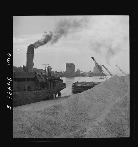 Untitled photo, possibly related to: Oswego, New York. Unloading bauxite from a barge onto a Canadian boat which has come up through the inland waterways from Dutch Guiana