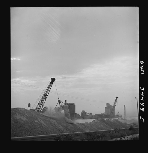 Oswego, New York. Unloading bauxite from a barge onto a Canadian boat which has come up through the inland waterways from Dutch Guiana