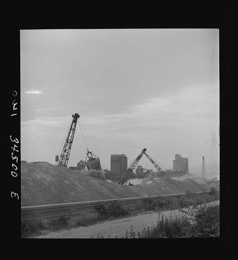 Oswego, New York. Unloading bauxite from a barge onto a Canadian boat which has come up through the inland waterways from Dutch Guiana