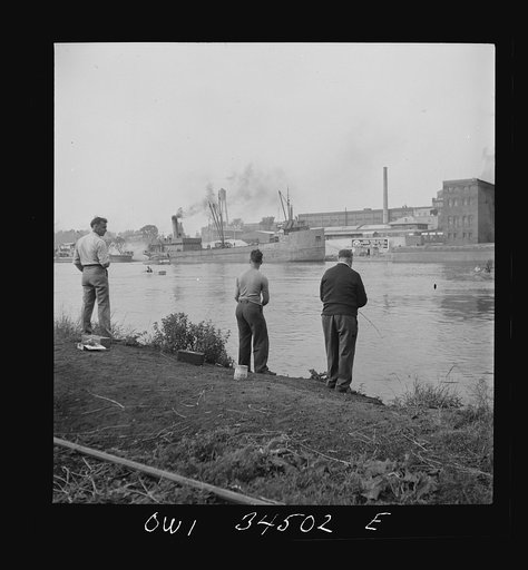 Oswego, New York. Sunday fishermen on the Oewego River opposite the bauxite docks