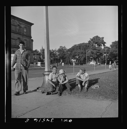 Untitled photo, possibly related to: Oswego, New York. Boys recruited to work on the farms during the summer waiting to be picked up by the farmers at 7:30 a.m.