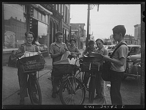 Untitled photo, possibly related to: Oswego, New York. The Palladium-Times, a daily afternoon paper, is distributed by these boys on bicycles. The congregate outside the newspaper office at 4 p.m. and fold papers before starting on their routes