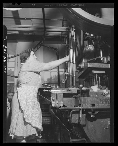 New Britain, Connecticut. Woman working in the Stanley plant operating a machine which cuts out material for steel bullet jackets