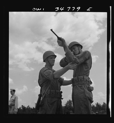 Warner Robins, Georgia. Air Service Command, Robins Field. Private Walter F. Guthrie, of Canadian, Texas, learning to handle a carbine. The instructor is Sergeant Dennis Maloney of Brooklyn, New York. Guthrie was a filling station operator in his home town; Maloney, a clerk in an A&P store. Both are
