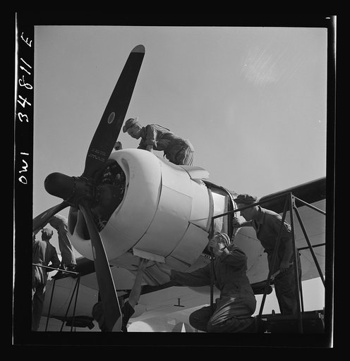 Warner Robins, Georgia. Air Service Command, Robins Field. Mechanics of an air depot group removing the cowling of one of the engines of a B-24 Liberator bomber