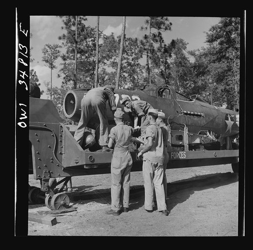 Untitled photo, possibly related to: Warner Robins, Georgia. Air Service Command, Robins Field. Practicing picking up and loading of an old P-39 with a C3 truck and trailer