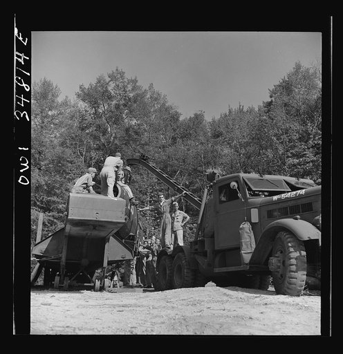 Untitled photo, possibly related to: Warner Robins, Georgia. Air Service Command, Robins Field. Practicing picking up and loading of an old P-39 with a C3 truck and trailer