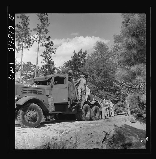 Untitled photo, possibly related to: Warner Robins, Georgia. Air Service Command, Robins Field. Practicing picking up and loading of an old P-39 with a C3 truck and trailer