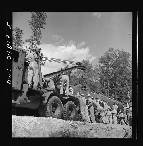 Untitled photo, possibly related to: Warner Robins, Georgia. Air Service Command, Robins Field. Practicing picking up and loading of an old P-39 with a C3 truck and trailer