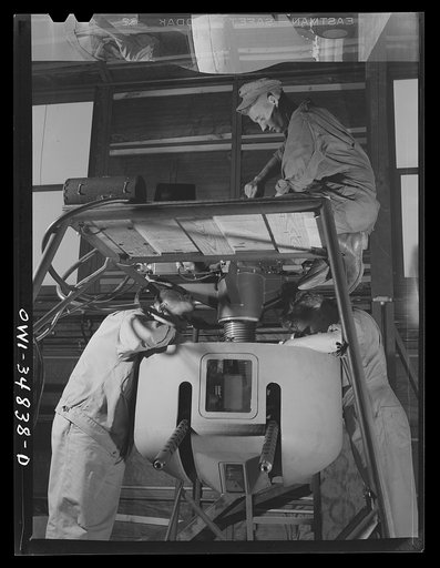 Untitled photo, possibly related to: Warner Robins, Georgia. Air Service Command, Robins Field. Men of an air depot group studying the mechanism of one of the turrets of a bomber