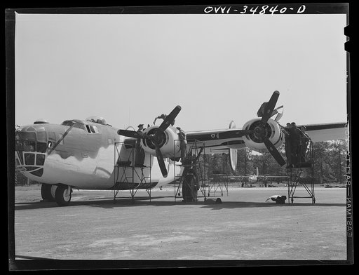 Untitled photo, possibly related to: Warner Robins, Georgia. Air Service Command, Robins Field. Mechanics removing the cowling of one of the engines of a B-24 bomber