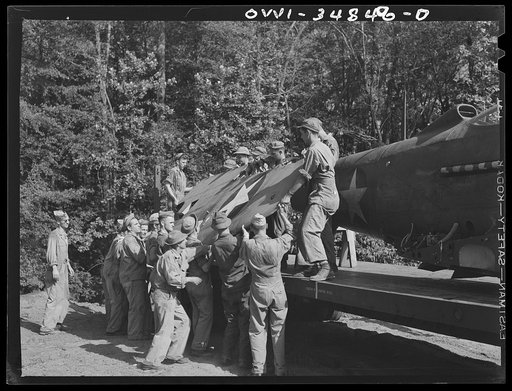 Untitled photo, possibly related to: Warner Robins, Georgia. Air Service Command, Robins Field. Practicing the loading of a simulated wreck onto a C-3 truck and trailer. An old P-39 was used for the demonstration