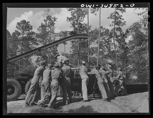 Untitled photo, possibly related to: Warner Robins, Georgia. Air Service Command, Robins Field. Practicing the loading of a simulated wreck onto a C-3 truck and trailer. An old P-39 was used for the demonstration