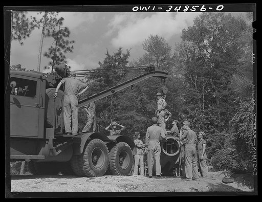 Untitled photo, possibly related to: Warner Robins, Georgia. Air Service Command, Robins Field. Practicing the loading of a simulated wreck onto a C-3 truck and trailer. An old P-39 was used for the demonstration