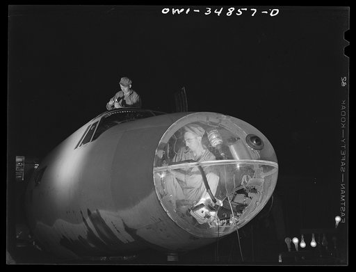Warner Robins, Georgia. Air Service Command, Robins Field. Aircraft mechanic working in the nose of a B-26 bomber at night