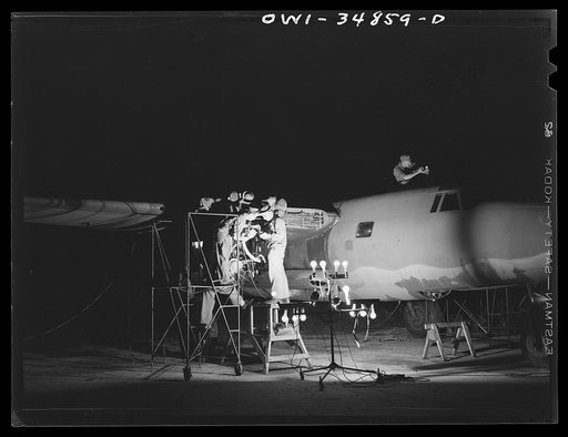 Warner Robins, Georgia. Air Service Command, Robins Field. Aircraft mechanic working in the nose of a B-26 bomber at night