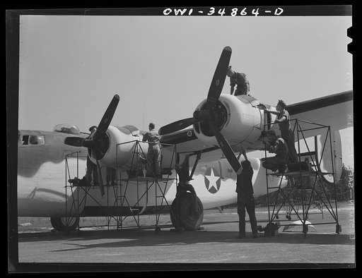 Warner Robins, Georgia. Air Service Command, Robins Field. Aircraft mechanics removing the cowling from the engines of a B-24 bomber