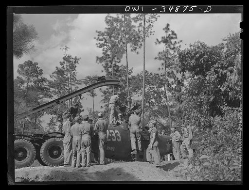 Untitled photo, possibly related to: Warner Robins, Georgia. Air Service Command, Robins Field. Practicing picking up and loading of an old P-39 with a C3 truck and trailer