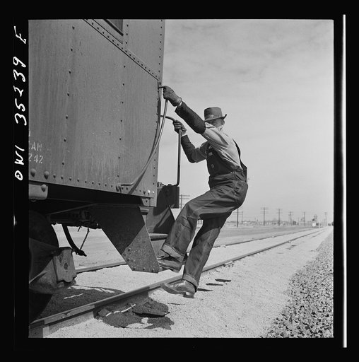 Texico, New Mexico. Conductor E.K. Hill about to get off the caboose as an Atchison, Topeka and Santa Fe train pulls into a siding