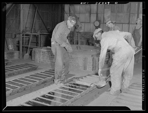 San Francisco, California. Pouring tin "pigs" at the metal and thermite company. The metal has been reclaimed from tin cans