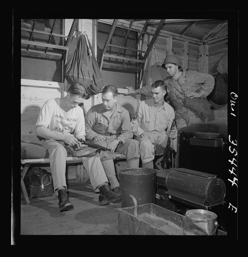 Greenville, South Carolina. Air Service Command. A scene in one of the barracks. The man on the left is cleaning his submachine gun