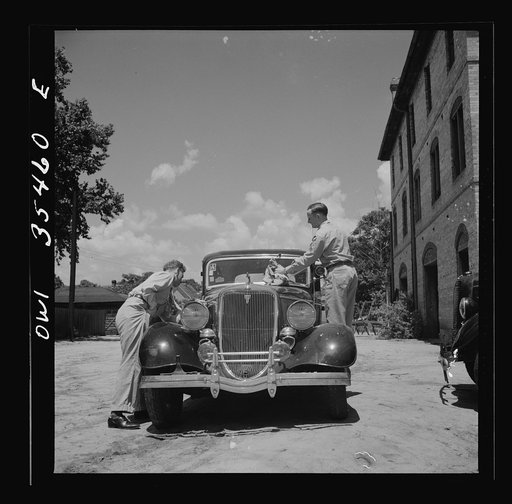 Bowman, South Carolina. Sergeant John Riley of the 25th service group, Air Service Command, on leave at his home. With the help of a friend, he is cleaning his little Ford, preparing to go see his girlfriend in Charleston, South Carolina