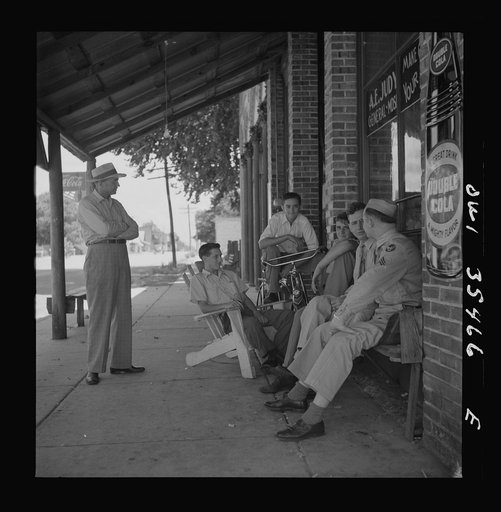 Untitled photo, possibly related to: Bowman, South Carolina. Sergeant John Riley of the 25th service group, Air Service Command, talking with friends while on leave at his home. Before enlisting in the Army, Sergeant Riley worked in his father's garage for many years