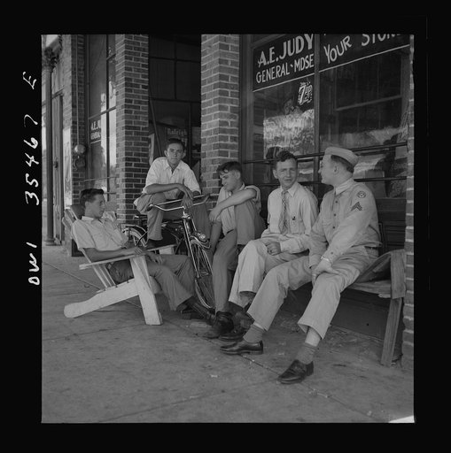 Bowman, South Carolina. Sergeant John Riley of the 25th service group, Air Service Command, talking with friends while on leave at his home. Before enlisting in the Army, Sergeant Riley worked in his father's garage for many years