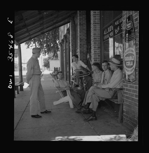 Bowman, South Carolina. Sergeant John Riley of the 25th service group, Air Service Command, talking with friends while on leave at his home. Before enlisting in the Army, Sergeant Riley worked in his father's garage for many years