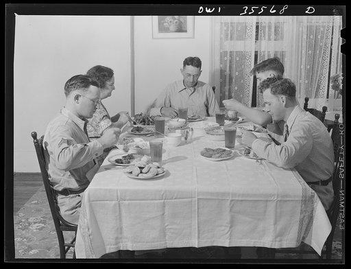 Bowman, South Carolina. Sergeant John Riley, of the 25th service group, Air Service Command, home on leave having dinner with his family and a friend