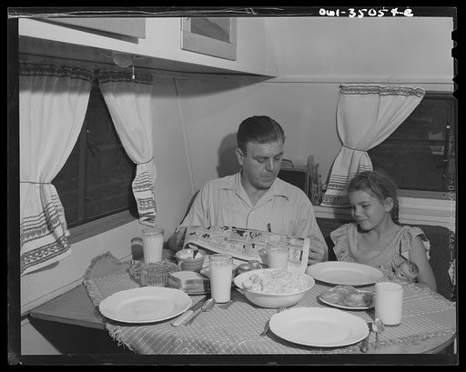 Middle River, Maryland. FSA (Farm Security Administration) housing project for Glenn L. Martin aircraft workers. Mr. Gaw reading to his child at the supper table in their trailer home