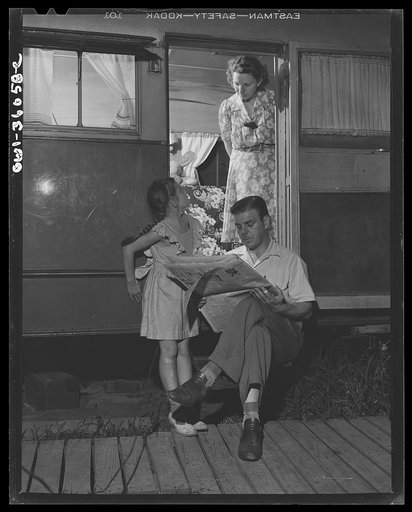 Middle River, Maryland. FSA (Farm Security Administration) housing project for Glenn L. Martin aircraft workers. Mrs. Emma D. Gaw with her six year old daughter and husband who works at the Glenn Martin plant, enjoying the cool of the evening in the doorway of trailer home