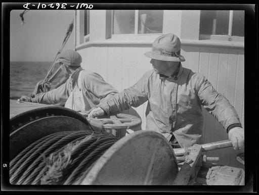 On board a fishing vessel out from Gloucester, Massachusetts. Winch control men intent on seeing to it that the proper amount of cable is let out at the proper spot